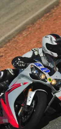 Rev up your phone's display with this high-octane live wallpaper featuring a motorcyclist racing on a track in Spain
