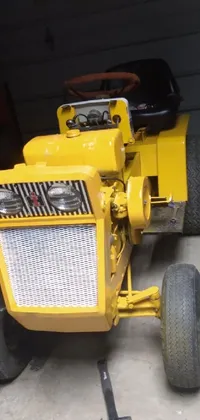 This phone live wallpaper depicts a playful scene of a yellow lawn mower parked inside a garage, surrounded by fun and whimsical details