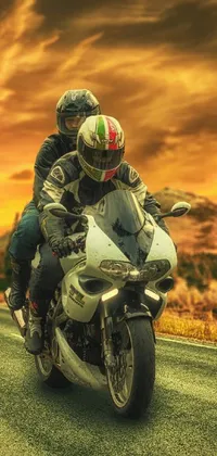 This phone live wallpaper showcases an exhilarating photorealistic image of a motorcycle rider on a road at sunset