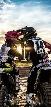 This live phone wallpaper depicts two riders on dirt bikes racing against a stunning sunset backdrop