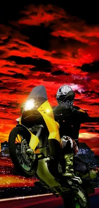 This phone live wallpaper showcases a captivating image of a man on a yellow motorcycle against a red sky background