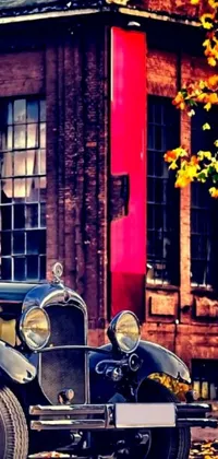 This phone live wallpaper showcases a vintage car parked in front of a brick building, set against an autumnal backdrop
