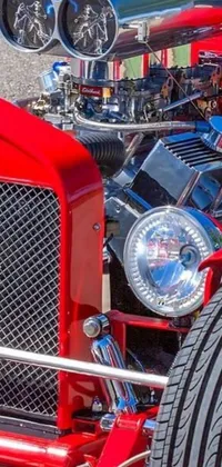 This dynamic live phone wallpaper shows a close-up of a red hot rod car, highlighted with sparkling chrome accents, cool headlights, pistons, and bolts