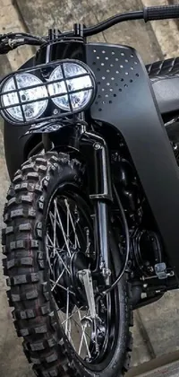 Rev up your phone screen with this bold black motorcycle parked in front of a textured wall live wallpaper