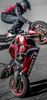 This crimson-themed phone live wallpaper depicts a skilled motorcycle rider performing an impressive trick