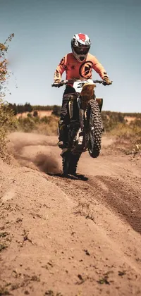 Experience the ultimate rush with this live phone wallpaper, featuring an action-packed moment of a dirt bike rider on a rough dirt road