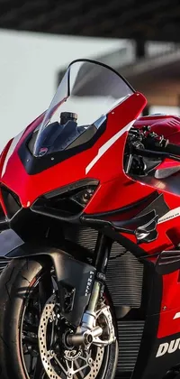 Looking for a stunning phone live wallpaper? Check out this red motorcycle parked in front of a building! The armor of the bike is a beautiful high-tech red, and the frontal close-up shows off the Diablo or R6 model