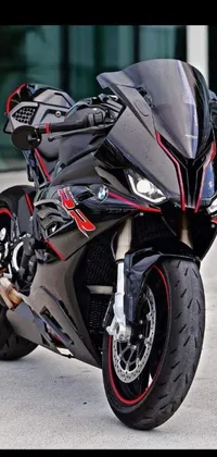 This live phone wallpaper showcases a striking black and red BMW motorcycle parked in front of a building