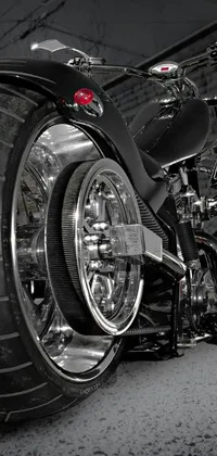 This phone live wallpaper features a close-up shot of a black wheeled motorcycle parked in a garage