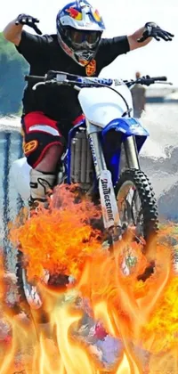 This dynamic live wallpaper features a photorealistic image of a dirt bike rider, accompanied by realistic flames or fire in the background