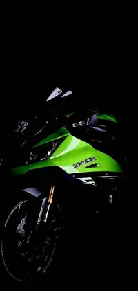 This live phone wallpaper features a stunning green and black motorcycle in the darkness