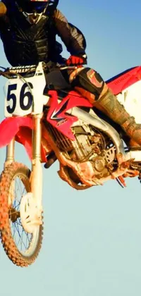This live wallpaper features an exhilarating image of a dirt biker flying through the air