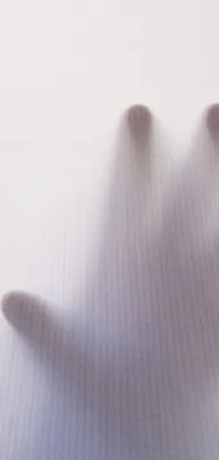 This phone live wallpaper features a close-up shot of a hand with a hazy background and misty shadows