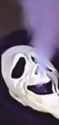 This unique phone live wallpaper features a close-up of a white masked figure set against a backdrop of purple smoke