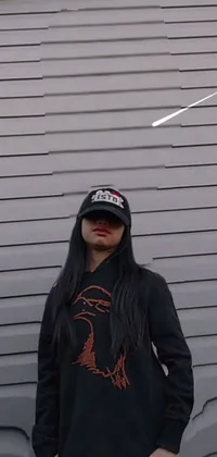 This funky live wallpaper depicts a confident woman sporting a rap cap and long black and red hair standing in front of a garage door
