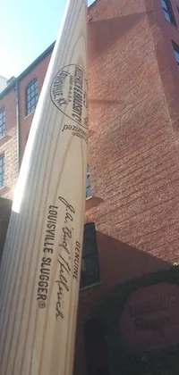 This wooden baseball bat live wallpaper features an engraved design of players in action on a baseball diamond