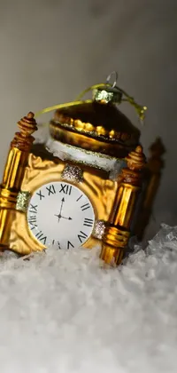 Looking for a phone live wallpaper that is both captivating and enchanting? Look no further than this beautiful gold clock sitting atop a pile of snow with a photo in baroque-style detailing