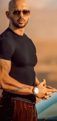 This live wallpaper features a man standing next to a red sports car in the desert, wearing a black t-shirt