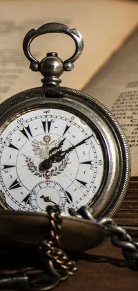 Enhance your phone's wallpaper with this vintage-inspired live wallpaper featuring a pocket watch set against a background of old paper