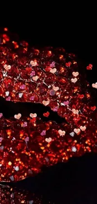 The phone live wallpaper showcases a vivid rendering of red glittered lips, enveloped by precious stones, garnet, and heart-shaped elements