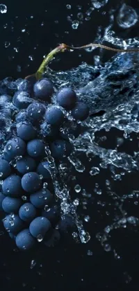 This live wallpaper features a digital art depiction of a bunch of grapes getting splashed with water