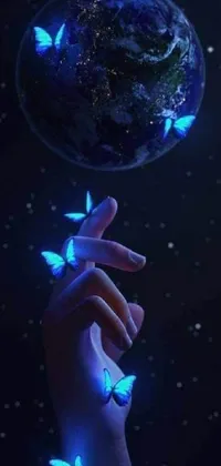 This phone live wallpaper features a stunning and symbolic image of a glowing earth held by a hand with fluttering butterflies around it