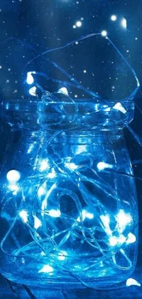 This phone live wallpaper portrays a glass jar filled with twinkling fairy lights on a wooden table