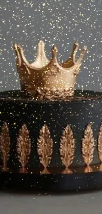 This striking phone live wallpaper features a detailed black and gold cake with a regal crown on top