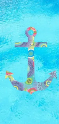 Looking for a fun and vibrant live wallpaper for your phone? Check out this digital rendering of an inflatable anchor floating in a pool! The anchor is designed in a dot-art style and set against a colorful, summer-themed background featuring an arabesque pattern
