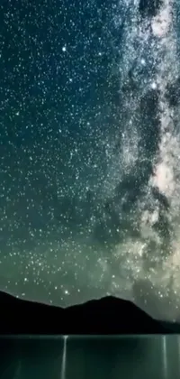 This mesmerizing phone live wallpaper showcases a starry night sky above a tranquil body of water