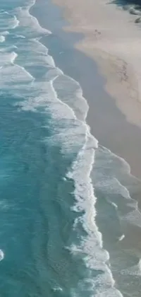 This phone live wallpaper showcases a stunning scene of a vast water body outlined by a sandy beach