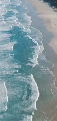 This mobile live wallpaper showcases the beauty of the South African coast, featuring soaring waves crashing onto a sandy beach