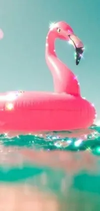 Looking to add some tropical flair to your phone? Check out this live wallpaper featuring a pink flamingo floating on the water, surrounded by bright and playful emojis
