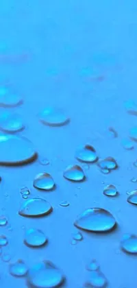 This mobile wallpaper displays a mesmerizing close-up shot of water droplets on a stunning blue surface
