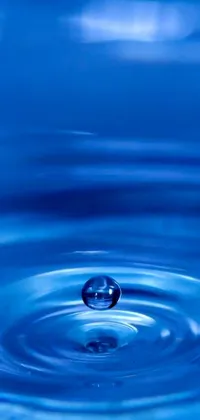 This phone live wallpaper features a stunning close up of a water drop submerged in water - a perfect balance of flickr digital art, with a beautiful blue background colour