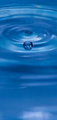 This phone live wallpaper features a stunning close-up of a water drop on a blue background