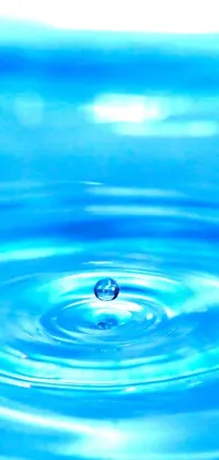This stunning live wallpaper for your phone features a minimalist yet captivating image of a single drop of water falling into a body of water
