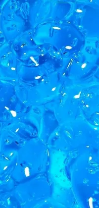 This live phone wallpaper showcases a stunning close-up of a blue liquid surface with backscatter orbs that appear cold as ice