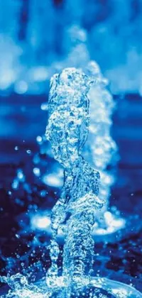 Transform your mobile device background with a stunning live wallpaper featuring a striking close-up of a majestic water fountain illuminated by calming blue lights