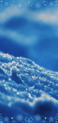 This live phone wallpaper captures the intricate details of a snow-covered ground in a close-up macro photograph