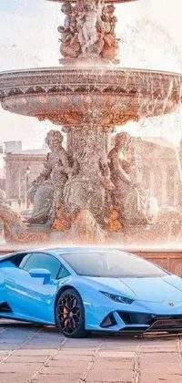 This remarkable phone live wallpaper features a stunning blue sports car parked in front of a baroque fountain