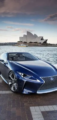 Get ready to elevate your phone screen with our blue sports car live wallpaper! The wallpaper depicts a stylish sports car parked in front of the iconic Sydney Opera House in a Tumblr style aesthetic