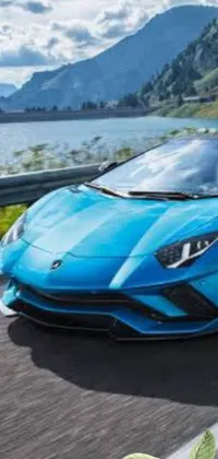 Looking for a visually appealing live wallpaper? Check out this cool design featuring a sporty blue Lamborghini Aventador driving next to a tranquil body of water