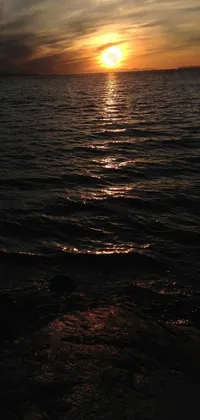 Experience the beauty of nature every time you look at your phone with our Sun Setting Over Water live wallpaper