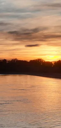 This live wallpaper depicts a stunning sunset over a river