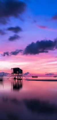 This live phone wallpaper features a serene scene of a small boat docked near a jetty on a body of water in Cambodia