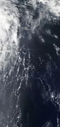 This mesmerizing phone wallpaper showcases a breathtaking satellite view of a vast ocean or sea with swirling clouds in the background