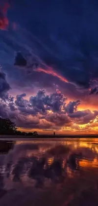 This live wallpaper displays a stunning scenery of a large body of water under a cloudy sky with a beautiful violet and yellow sunset, captured in a romanticism style