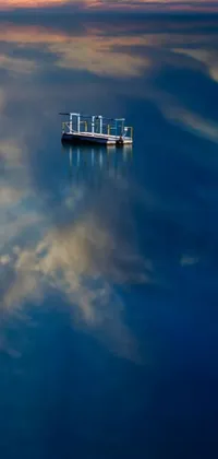 This phone live wallpaper features a serene scene of a boat effortlessly floating on a large body of water