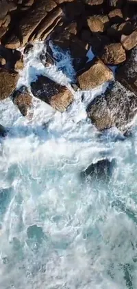 This dynamic live phone wallpaper features a surfer riding a wave with streams and rocks in the background